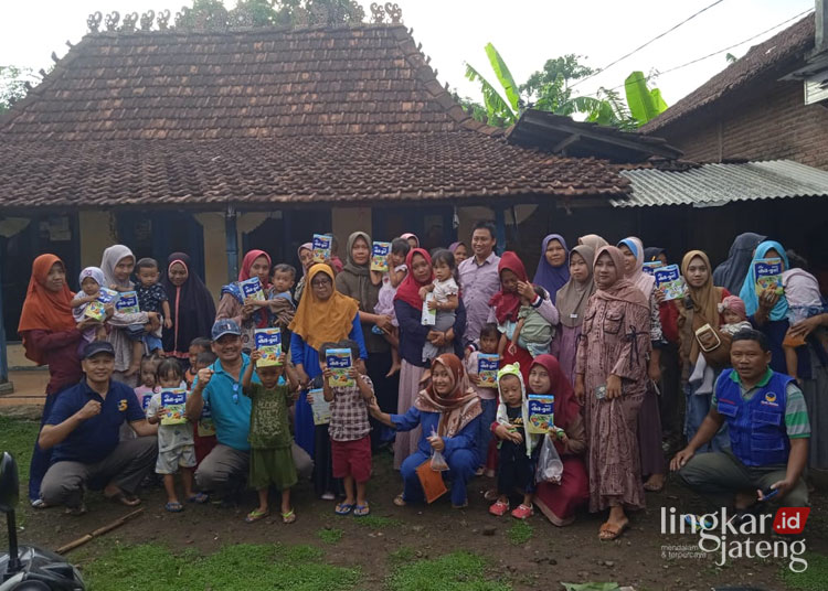 BANTUAN: Wakil Ketua Dewan Perwakilan Rakyat Daerah (DPRD) Kabupaten Jepara, Pratikno saat membagikan bantuan susu kotak kepada Balita di Desa Ngabul dan Sowan Kidul. (Tomi Budianto/Lingkarjateng.id)