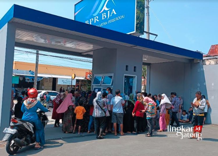 ANTRE: Para nasabah terlihat antre di depan Kantor Bank Jepara Artha untuk melakukan penarikan simpanan, belum lama ini. (Tomi Budianto/Lingkarjateng.id)