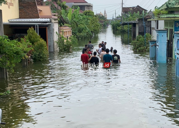 BANJIR: Sejumlah warga menerjang banjir di Desa Undaan Lor, Karanganyar, Kabupaten Demak, Sabtu, 10 Februari 2024. (M. Burhanuddin Aslam/Lingkarjateng.id)