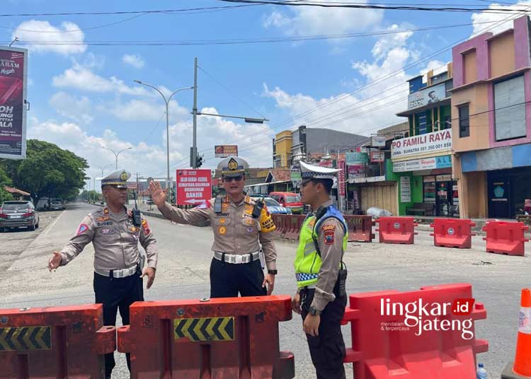 MENGATUR LALU LINTAS: Anggota Satlantas Polres Demak melakukan rekayasa penutupan jalur Simpang 3 Trengguli, Demak paa Rabu, 14 Februari 2024. (M. Burhanuddin Aslam/Lingkarjateng.id)
