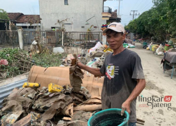 KUMUH: Warga Kecamatan Karanganyar, Kabupaten Demak membersihkan sampah-sampah usai banjir surut, Minggu, 18 Februari 2024. (M. Burhanuddin Aslam/Lingkarjateng.id)