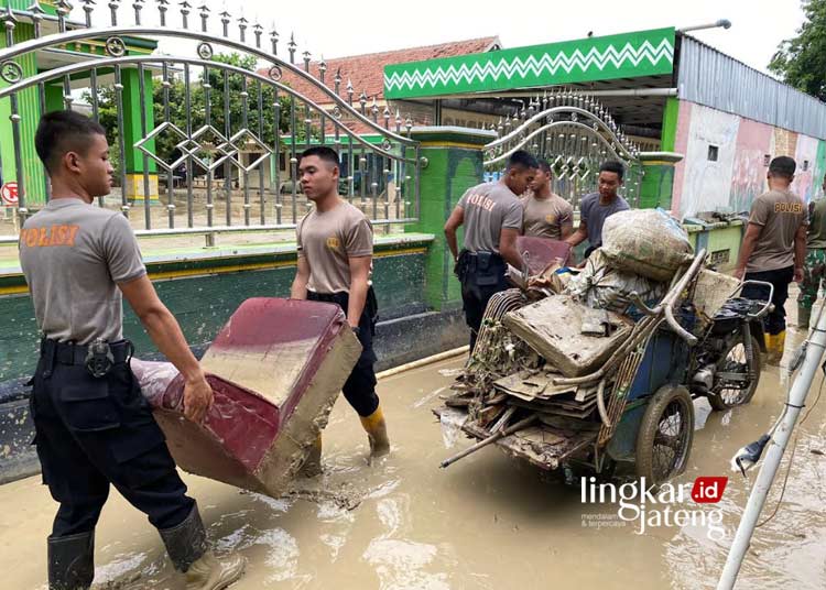 GOTONG ROYONG: Petugas gabungan yang terdiri dari TNI, Polri, dan BPBD Kabupaten Grobogan membersihakan sisa endapan lumpur yang terbawa oleh banjir pada Sabtu, 10 Februari 2024. (Dok. Polres Grobogan/Lingkarjateng.id)