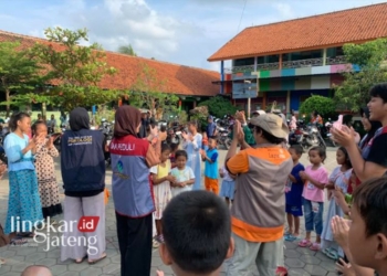 TRAUMA HEALING: Relawan Psikososial Universitas Muhamadiyah Purwokerto sedang mengajak anak-anak korban banjir bermain, di posko pengungsian SDN Gajah 2, Senin, 12 Februari 2024. (M Burhanuddin Aslam/Lingkarjateng.id)