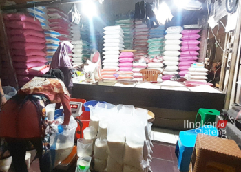 MELAYANI PEMBELI: Pedagang beras sedang melayani pembeli di Pasar Induk Purwodadi, Kabupaten Grobogan. (Eko Wicaksono/Lingkarjateng.id)