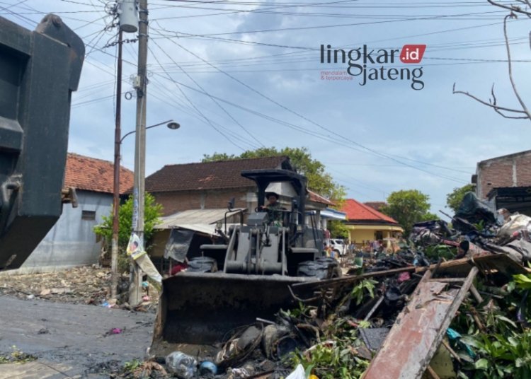 SIGAP MEMBANTU: Prajurit Yonzipur 4/TK mengoperasikan alat berat untuk membantu mempercepat pembersihan sisa banjir di Kabupaten Demak. (Dok. Pangdam IV/Diponegoro for Lingkar/Lingkarjateng.id)
