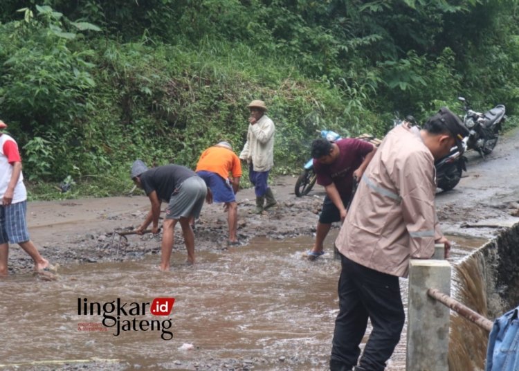 BERGOTONG ROYONG : Warga, dan juga para relawan gabungan, TNI-Polri bersama-sama membersihkan sisa-sisa material yang terbawa banjir bandang. (Hesty Imaniar/Lingkarjateng.id)