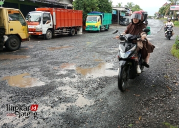 MELINTAS: Pengendara motor melintasi jalan rusak dengan hati-hati di jalan Kelet-Sambungoyot, Kecamatan Keling, Kabupaten Jepara. (Muhammad Aminudin/Lingkarjateng.id)