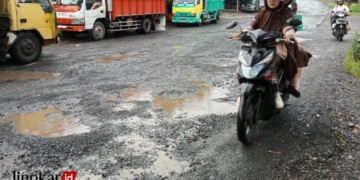 MELINTAS: Pengendara motor melintasi jalan rusak dengan hati-hati di jalan Kelet-Sambungoyot, Kecamatan Keling, Kabupaten Jepara. (Muhammad Aminudin/Lingkarjateng.id)