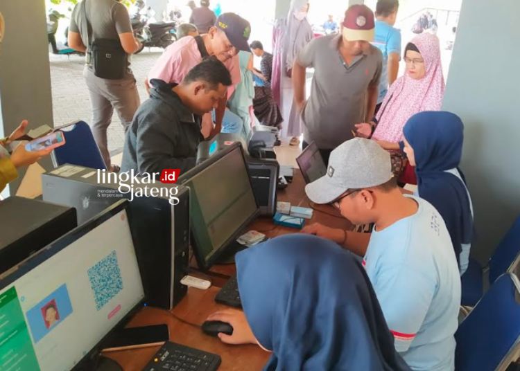 PELAYANAN ADMINDUK: Petugas Dispendukcapil Kabupaten Kendal memberikan layanan administrasi kependudukan di Stadion Kebondalem Kabupaten Kendal pada Minggu, 11 Februari 2024. (Robison/Lingkarjateng.id)