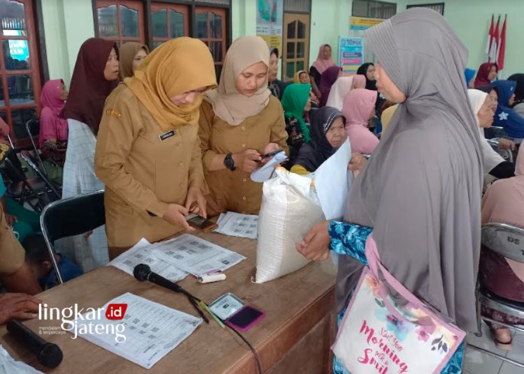 SERAH TERIMA: Warga Desa Kalirejo, Kecamatan Kangkung, Kabupaten Kendal mengambil bantuan beras di kantor kepala desa setempat pada Senin, 5 Februari 2024. (Arvian Maulana/Lingkarjateng.id)