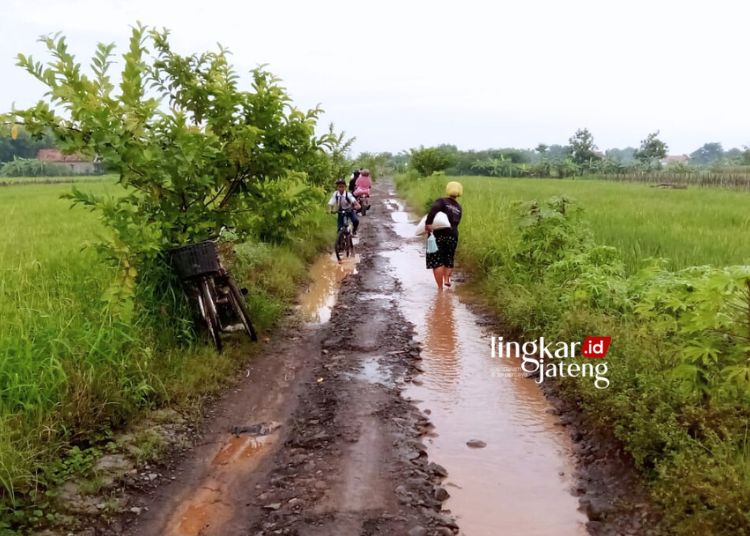 JALAN RUSAK: Tampak warga sedang melewati Jalan Dusun Gendengan, Desa Sukodono, Kecamatan/Kabupaten Kendal. (Robison Lingkarjateng.id)