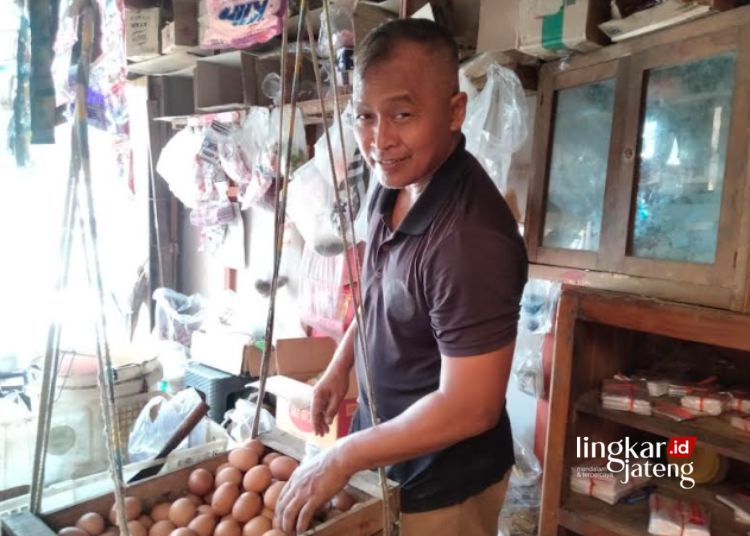 MENJUAL: Seorang pedagang sembako di Pasar Randublatung, Kabupaten Blora, Agus, sedang menata dagangannya. (Hanafi/Lingkarjateng.id)