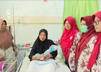 BAHAGIA: Sukarti sedang menggendong sang buah hati yang lahir di Tahun Kabisat dengan didampingi petugas kesehatan di RSI Arafah Rembang, Kamis, 29 Februari 2024. (Vicky Rio/Lingkarjateng.id)