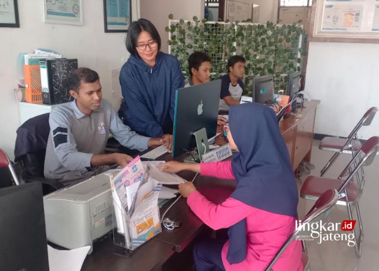 BERI LAYANAN: Kepala Bidang Perlindungan Jaminan Sosial dan Data Penyuluhan pada Dinas Sosial Kabupaten Kendal, Ria Listianasari dan staff saat melayani salah satu warga. (Arvian Maulana/Lingkarjateng.id)