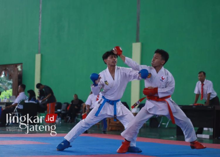 DALAM LAPANGAN: Tampak dua orang peserta karate pada ajang Popda Kabupaten Kudus yang diselenggarakan di GOR Lapangan Indoor Wergu Wetan Kudus, Kamis, 7 Maret 2024. (Nisa Hafizhotus Syarifa/Lingkarjateng.id)