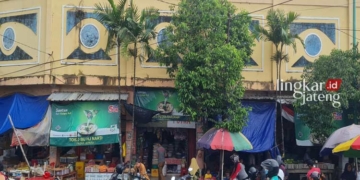 RAMAI: Beberapa pengunjung pasar sedang lalu lalang melintasi jalan di samping Pasar Ratu 2 Jepara. (Muhammad Aminudin/Lingkarjateng.id)