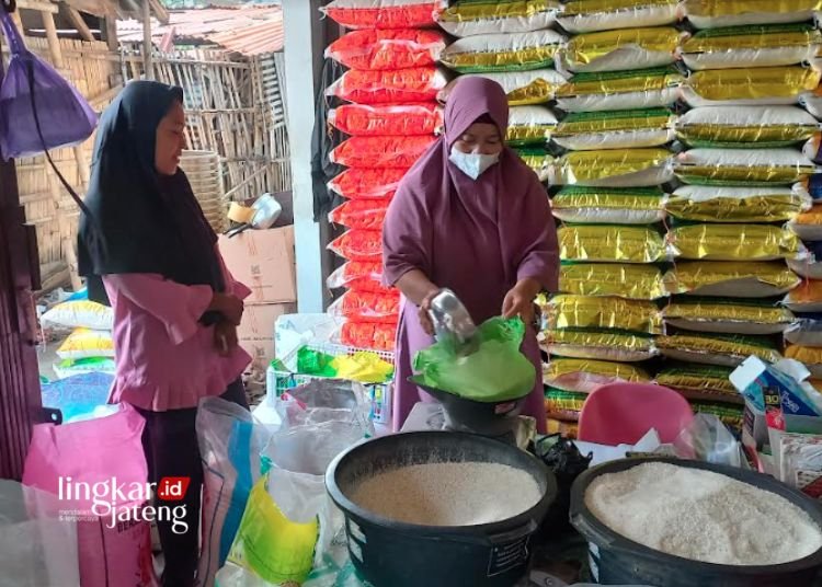 MELAYANI PEMBELI: Seorang pedagang beras sedang melayani pembeli di pasar tradisional Kendal. (Arvian Maulana/Lingkarjateng.id)