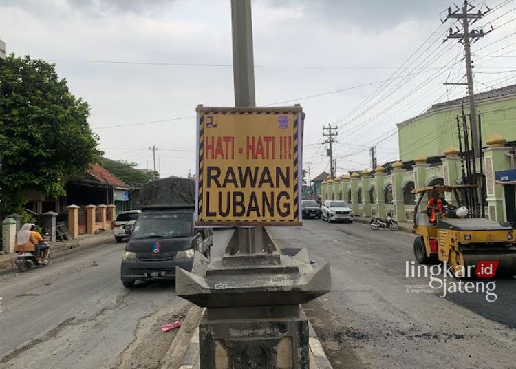Jalan Pantura Karanganyar Demak yang Rusak Akibat Banjir Diperbaiki, Target Selesai H-5 Lebaran 25 DIPERBAIKI: Papan peringatan yang dipasang di sekitar proyek perbaikan Jalan Pantura Karanganyar yang rusak karena terendam banjir beberapa hari lalu oleh pihak terkait, Senin, 25 Maret 2024. (M. Burhan A/Lingkarjateng.id)