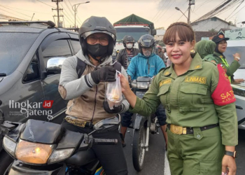BERBAGI: Pasukan dari Srikandi Satgas Linmas Kabupaten Semarang tengah melakukan kegiatan sosial bagi-bagi takjil di bulan Ramadhan ini kepada pengguna jalan yang melintas di traffic light depan kantor Polsek Bergas, Kabupaten Semarang, Minggu, 24 Maret 2024. (Hesty Imaniar/Lingkarjateng.id)