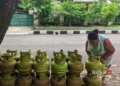 PENGECER: Seorang pengecer gas bersupsidi sedang menata tumpukan gas LPG 3 kg. (Setyo Nugroho/Lingkarjateng.id)