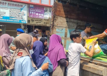 TERTIB: Masyarakat antre untuk mendapatkan sembako murah di operasi pasar murah yang digelar oleh Pemkab Jepara. (Muhammad Aminudin/Lingkarjateng.id)