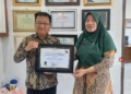 BANGGA: Kepala Dinsos Kendal dan Sekretaris Dinsos Kendal memegang piagam penghargaan dari Ombudsman RI. (Arvian Maulana/Lingkarjateng.id)