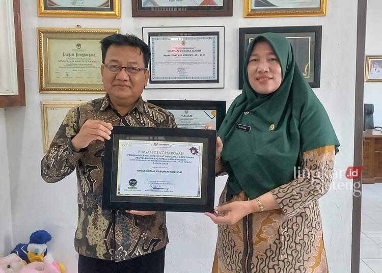 BANGGA: Kepala Dinsos Kendal dan Sekretaris Dinsos Kendal memegang piagam penghargaan dari Ombudsman RI. (Arvian Maulana/Lingkarjateng.id)