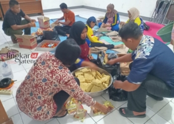 MENYIAPKAN BAHAN MAKANAN: Dinsos Kendal saat menyiapkan bahan makanan yang akan diolah untuk dibagikan kepada warga terdampak banjir. (Unggul Priambodo/Lingkarjateng.id)