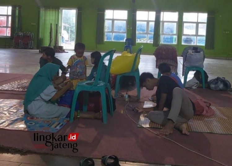 MENGUNGSI: Tampak warga yang terdampak banjir mulai mengungsi di Balai Desa Jati Wetan, Kecamatan Jati, pada Kamis, 14 Maret 2024. (Nisa HS/Lingkarjateng.id)