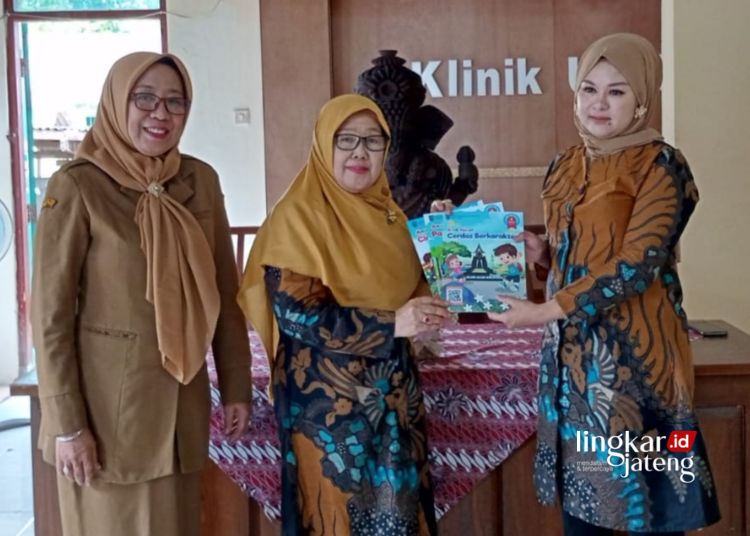 SIMBOLIS: Kepala Dinas Perpustakaan dan Kearsipan Kota Salatiga Sri Sarwanti (kiri) membagikan buku untuk anak usia dini kepada masyarakat, belum lama ini. (Dok.Dinpersip Salatiga/Lingkarjateng.id)