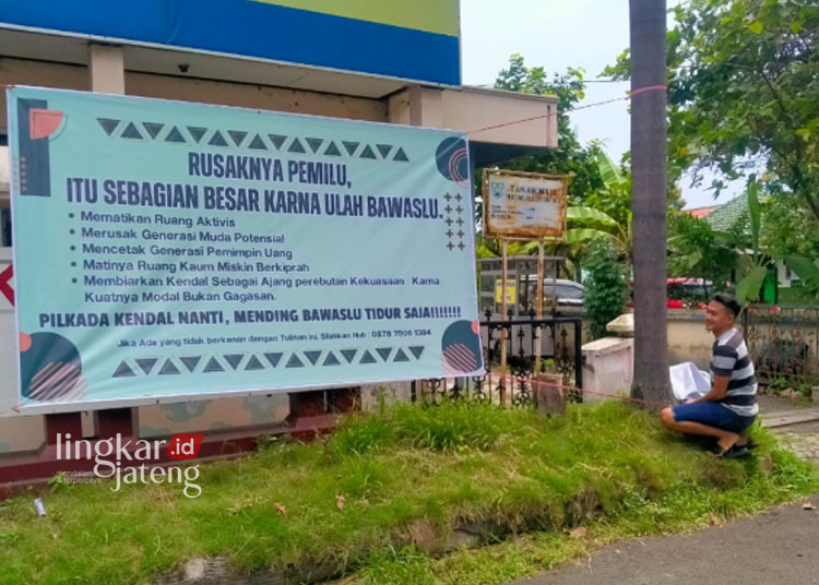 Nizam tampak sedang memasang Baliho di depan Kantor KPU sebelum akhirnya dicopot, Jumat, 1 Maret 2024. (Dok. Lingkarjateng.id)