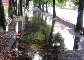 TERGENANG: Jalur lambat khusus sepeda motor di jalan Pati-Kudus berubah menjadi kolam lele setelah diguyur hujan lebat, Minggu 21 April 2024. (Arif Febriyanto/Lingkarjateng.id)