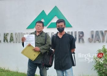 Al May Galih Pratama Nasution bersama Kuasa hukumnya, Nur Zuliadi saat memperlihatkan surat perjanjian kerja. (Tomi Budianto/Lingkarjateng.id)