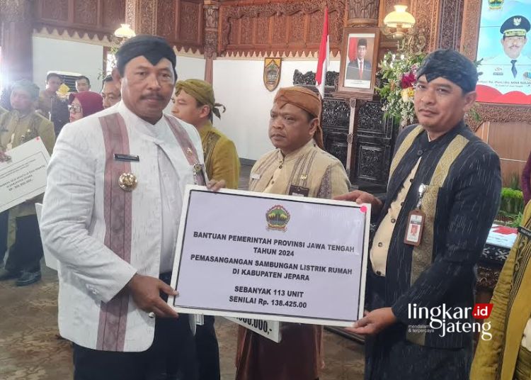 SIMBOLIS: Penjabat (Pj) Gubernur Jawa Tengah, Nana Sudjana, menyerahkan bantuan pemasangan listrik rumah kepada salah satu OPD Jepara di Pendopo RA Kartini, Kamis, 18 April 2024. (Muhammad Aminudin/Lingkarjateng.id)