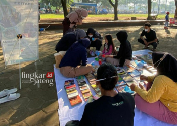 RIANG GEMBIRA: Anak-anak mengerumuni lapak baca yang disiapkan Komunitas Rumah Baca Kreatif di Alun-alun Juwana, Kabupaten Pati setiap Minggu. (Setyo Nugroho/Lingkarjateng.id)