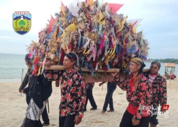 NGURI-URI BUDAYA: Sejumlah warga membopong salah satu jembul dalam Festival Budaya Jembul Banyumanis di Objek Wisata Pantai Tirto Samudro, Bandengan, Kabupaten Jepara pada Minggu, 12 Mei 2024. (Muhammad Aminudin/Lingkarjateng.id)