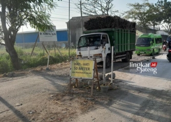 PERBAIKAN JALAN: Tampak sejumlah transportasi hendak melintas di Jalan Wirosari-Kradenan dengan berhati-hati. (Eko Wicaksono/Lingkarjateng.id)