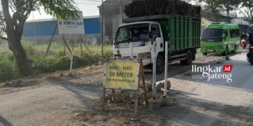 PERBAIKAN JALAN: Tampak sejumlah transportasi hendak melintas di Jalan Wirosari-Kradenan dengan berhati-hati. (Eko Wicaksono/Lingkarjateng.id)