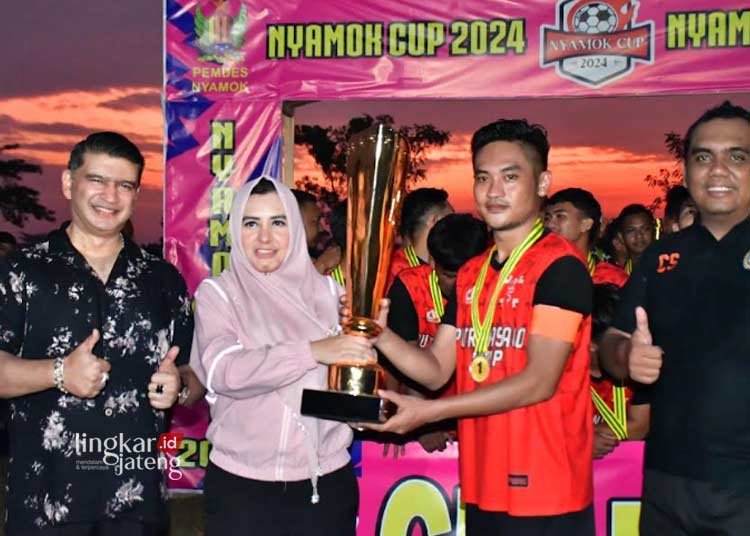 Bupati Pekalongan Fadia Arafiq menyerahkan hadiah secara simbolis kepada PSG Gembong Kedungwuni sebagai juara pertama dalam Penutupan Final Turnamen Sepakbola Nyamok Cup 2024 yang digelar di Lapangan Tambor, Desa Nyamok, Kecamatan Kajen, pada Minggu sore, 24 Juni 2024. (Fahri Akbar/Lingkarjateng.id)
