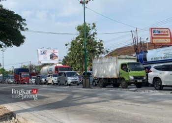 Kendaraan roda empat maupun truk besar berhenti lantaran terjebak kemacetan di Jalan Pantura Karanganyar, Demak, pada Minggu, 30 Juni 2024. (M. Burhanuddin Aslam/Lingkarjateng.id)