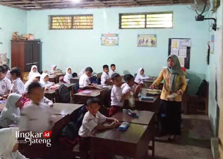 MENGAJAR: Seorang guru sedang menyampaikan materi pembelajaran kepada siswa sekolah dasar. (Tomi Budianto/Lingkarjateng.id)