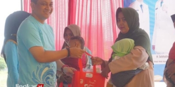 SIMBOLIS: Wali Kota Pekalongan, Achmad Afzan Arslan Djunaid, menyerahkan bingkisan olahan ikan kepada masyarakat dalam acara gerakan memasyarakatkan makan ikan (Gemari) untuk mencegah stunting pada baduta di Technopark Perikanan Kota Pekalongan pada Kamis, 13 Juni 2024. (Kominfo Kota Pekalongan/Lingkarjateng.id)