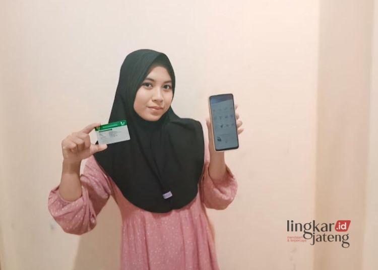 Dosen di Fakultas Ilmu Sosial dan Politik Universitas Negeri Walisongo Semarang, Dina Nilna Khusna (24), menunjukkan kartu JKN-KIS dan Mobile JKN. (Setyo Nugroho/Lingkarjateng.id)