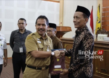 Sekda Jepara Edy Sujatmiko menyerahkan SK Pensiun kepada salah satu pensiuan, Senin, 1 Juli 2024. (Muhammad Aminudin/Lingkarjateng.id)