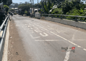 Potret jalan rusak dan tulisan “selamat datang di jalan seribu lubang” di Jalan Desa Gondangsari-Menawan, Kecamatan Gebog, Kabupaten Kudus. (Mohammad Fahtur Rohman/Lingkarjateng.id)