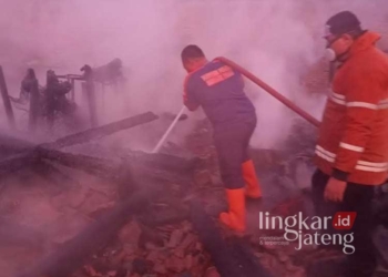 Petugas damkar saat berupaya melakukan pemadaman sisa api yang masih membakar tuga rumah di Dukuh Wedean, Desa Harjowinangun, Kecamatan Dempet, Kabupaten Demak, pada Kamis, 25 Juli 2024. (M. Burhanuddin Aslam/Lingkarjateng.id)