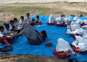 Suasana siswa SDN 1 Gedangan, Grobogan, belajar di luar ruangan beralaskan tikar. (Dok. Pribadi/Lingkarjateng.id)