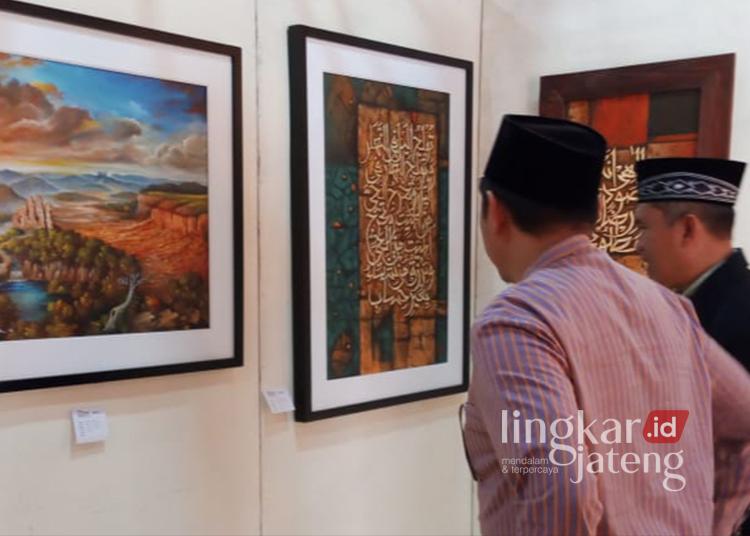 PAMERAN: Sejumlah warga melihat karya seni lukisan dan kaligrafi yang dipamerkan di Pendapa Bung Karno DPRD Kota Salatiga, Selasa, 16 Juli 2024. (Angga Rosa/Lingakrjateng.id)