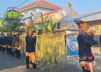 LESTARIKAN BUDAYA: Rombongan kirab mengantarkan gunungan yang berisi hasil bumi dan laut menuju Alun-alun Karimunjawa, Jepara, untuk merayakan tradisi Barikan Kubro. (Muhammad Aminudin/Lingkarjateng.id)