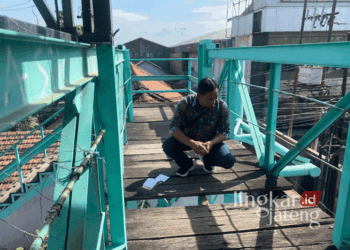 Suhardi, tenaga lapangan salah satu yayasan universitas di Kudus, saat melakukan pengecekan JPO Dersalam, Bae, Kudus, pada Rabu, 28 Agustus 2024. (Mohammad Fahtur Rohman/Lingkarjateng.id)